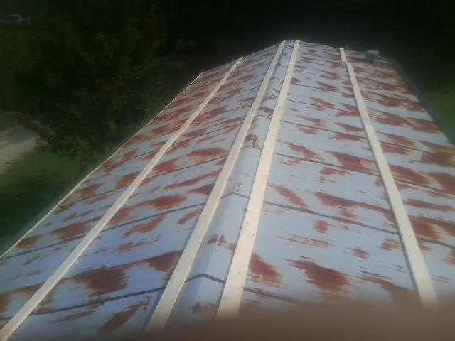 Rusted metal roof panels with new wood purlins before replacement — Storm Damage Roof Repair in Clintondale by Roofing Brothers